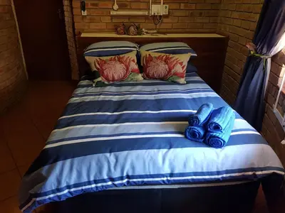 a bed with blue shoes sitting on top of it at Klein huisie in Marloth Park