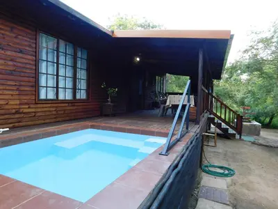 a swimming pool in the backyard of a house at Hout Huisie in Marloth Park