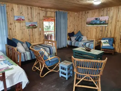 a living room with two beds and a table and chairs at Hout Huisie in Marloth Park