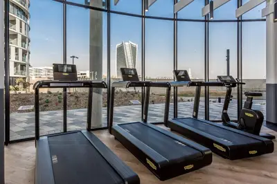 a gym with three treadmills in a building with windows at Kashi Skyline: Live . Shop . Work . Play in Midrand