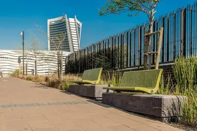 two green benches sitting next to a fence at Kashi Skyline: Live . Shop . Work . Play in Midrand