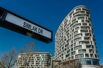 a street sign in front of a tall building at Kashi Skyline: Live . Shop . Work . Play in Midrand