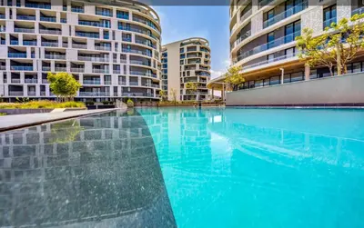 a large swimming pool in front of some buildings at Kashi Skyline: Live . Shop . Work . Play in Midrand