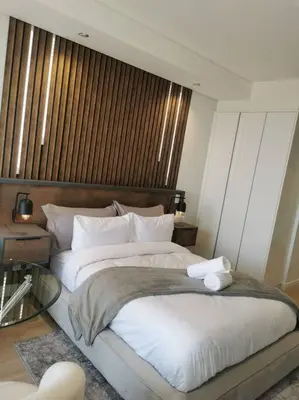 a bedroom with a large bed and a glass table at Kashi Skyline: Live . Shop . Work . Play in Midrand