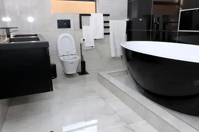 a bathroom with a tub and a toilet and a sink at The Residence Villa in Musina