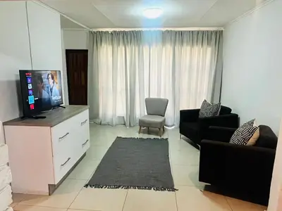 a living room with a tv on a dresser at The Hart House in Hartbeespoort