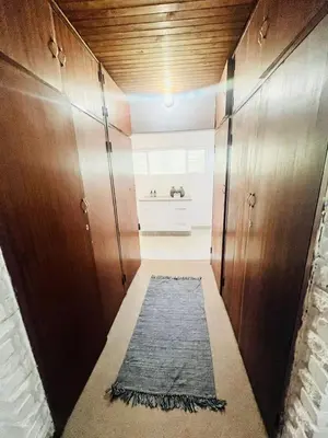 a hallway with wooden cabinets and a rug at The Hart House in Hartbeespoort