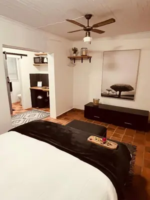a bedroom with a bed and a mirror on the wall at The Hart House in Hartbeespoort