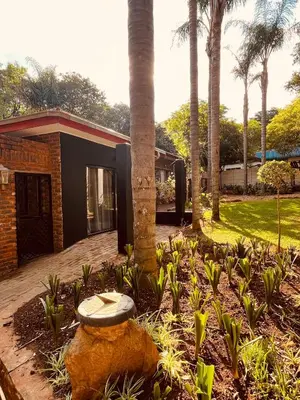 a house with a stone bench in a garden at The Hart House in Hartbeespoort