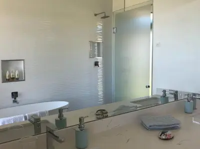 a bathroom with a sink and a large mirror at Walkersons Estate- Outcrop in Dullstroom