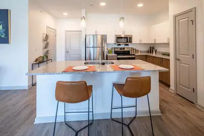 a kitchen with a large island with two bar stools at The Grove in Pretoria