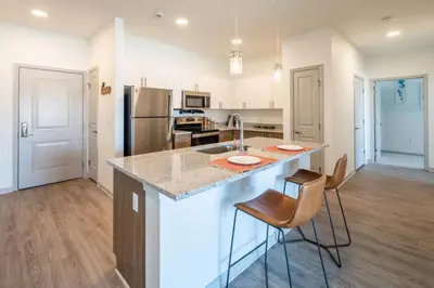 a kitchen with a counter and chairs in a room at The Grove in Pretoria