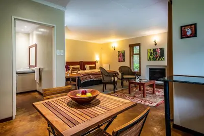 a living room with a table with a bowl of fruit on it at Kuhestan Farm Cottages in Haenertsburg