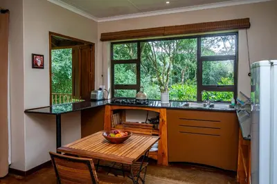 a kitchen with a table with a bowl of fruit on it at Kuhestan Farm Cottages in Haenertsburg