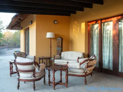 two chairs and a table on a porch at Kruger Wildlife Villas in Phalaborwa