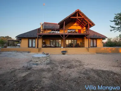 a large house with a thatched roof at Kruger Wildlife Villas in Phalaborwa