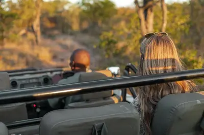 a man and a woman riding in a vehicle at Nsala Wilderness Camp in Timbavati Game Reserve