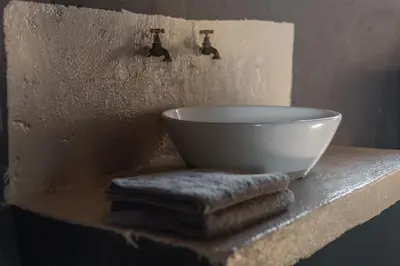 a white bowl sitting on a shelf with towels at Nsala Wilderness Camp in Timbavati Game Reserve