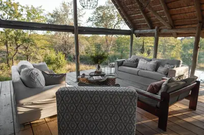 a patio with two couches and a table and a table at Nsala Wilderness Camp in Timbavati Game Reserve