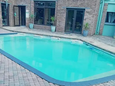 a swimming pool in front of a building at An Exclusive Guesthouse too in Nelspruit