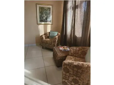 a living room with two chairs and a chair and a couch at An Exclusive Guesthouse too in Nelspruit