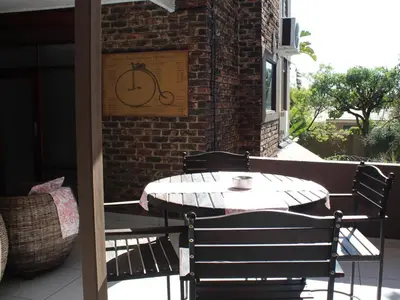 a table and chairs on a patio with a coffee cup on it at An Exclusive Guesthouse too in Nelspruit