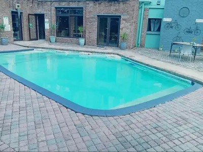 a swimming pool with blue water in a brick yard at An Exclusive Guesthouse too in Nelspruit