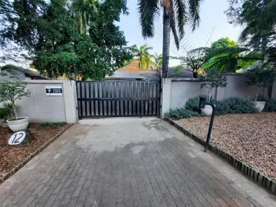 a driveway in front of a fence with a gate at Leadwood Guesthouse in Tzaneen