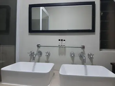 a bathroom with two white sinks and a mirror at Leadwood Guesthouse in Tzaneen