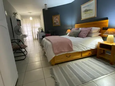 a bedroom with a bed and a blue wall at Serene Garden Suite in Pretoria