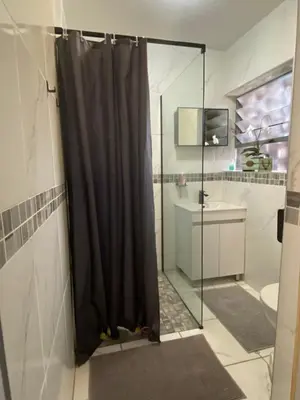 a bathroom with a shower with a black shower curtain at Serene Garden Suite in Pretoria