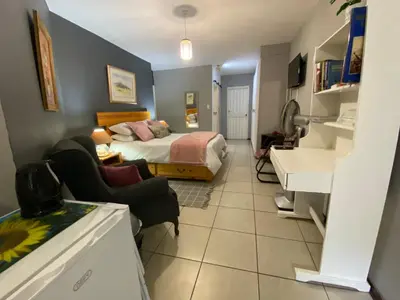 a bedroom with a bed and a living room at Serene Garden Suite in Pretoria