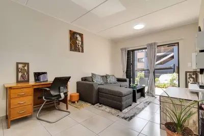 a living room with a couch and a desk at GroundEazy beside Mall of Africa in Midrand