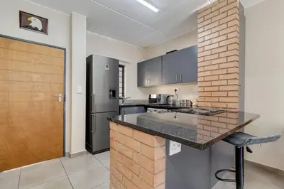 a kitchen with a counter and a refrigerator at GroundEazy beside Mall of Africa in Midrand