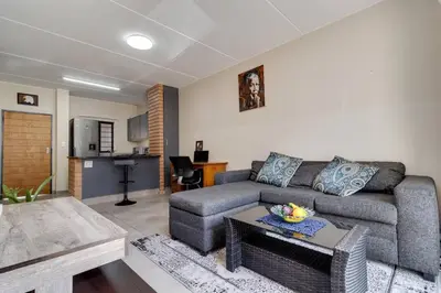 a living room with a couch and a table at GroundEazy beside Mall of Africa in Midrand