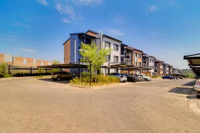 a parking lot with cars parked in front of a building at GroundEazy beside Mall of Africa in Midrand