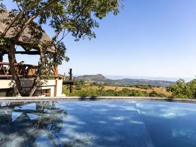 a swimming pool with a view of the mountains at Oluchi Lodge in Guthrie