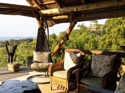 a porch with two chairs and a hammock at Oluchi Lodge in Guthrie