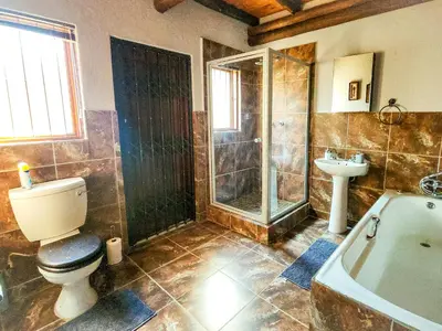 a bathroom with a toilet and a shower and a sink at Villa Zizi in Bela-Bela in Moheme
