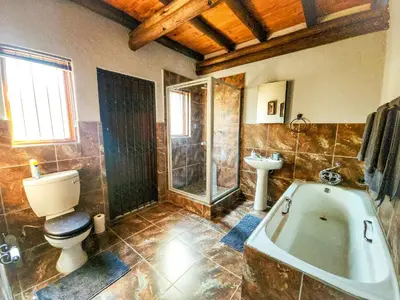 a bathroom with a tub and a toilet and a sink at Villa Zizi in Bela-Bela in Moheme
