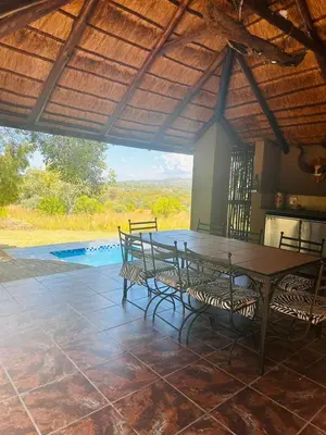 a patio with a table and chairs and a pool at Villa Zizi in Bela-Bela in Moheme