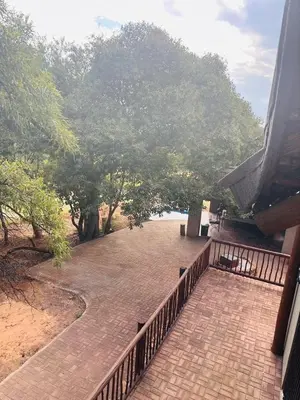 a brick walk way with a fence and trees at Villa Zizi in Bela-Bela in Moheme