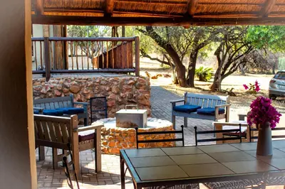 a patio with a table and chairs and a fireplace at Villa Zizi in Bela-Bela in Moheme