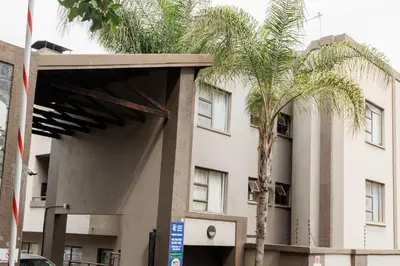 a building with a palm tree in front of it at Pamuzinda Airbnb at Urban Cove in Nelspruit