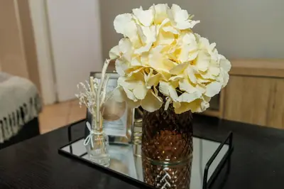 a vase filled with white flowers on a table at Pamuzinda Airbnb at Urban Cove in Nelspruit