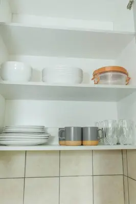 a white shelf with plates and dishes on it at Pamuzinda Airbnb at Urban Cove in Nelspruit