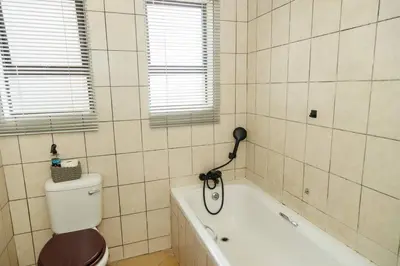 a bathroom with a toilet and a bath tub at Pamuzinda Airbnb at Urban Cove in Nelspruit
