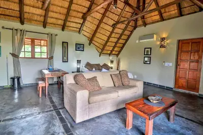 a living room with a couch and a table at Leopard Chalet - Solar System in Marloth Park