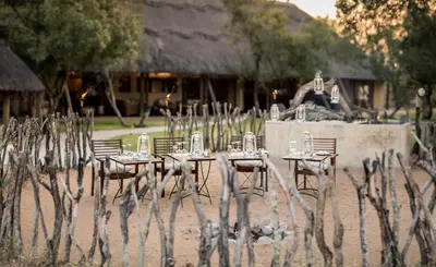a group of tables and chairs in front of a building at Tintswalo Safari in Manyeleti Game Reserve