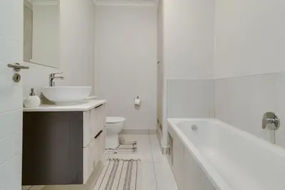 a bathroom with a tub and a sink and a toilet at Smartz Apartment312 in Midrand
